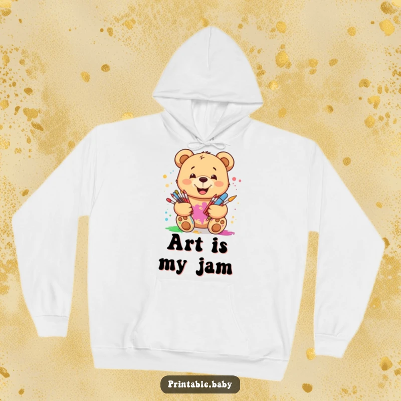 Funny smiling teddy bear hoodie, surrounded by art supplies with paint splatters, offering cozy comfort and artistic flair.